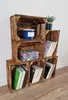 A set of wooden crates stacked to form a shelving unit, with decorative items and books placed inside. Produktbild-Vorschau