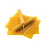 A pile of beeswax sheets and rolled beeswax candles with wicks. Náhled obrázku produktu