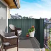A balcony with two chairs, a privacy screen, and potted plants. Produktbild-Vorschau