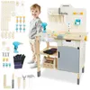 A young boy stands next to a wooden toy workbench with various tools and accessories. Produktbild-Vorschau
