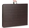 A folded dark brown table with a wood grain texture is being held by a person's hand via a black handle. Produktbild-Vorschau
