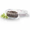 A glass food storage container filled with peppercorns, with a basil leaf to the side and the lid slightly ajar. Náhled obrázku produktu