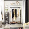 A dressing room or closet area with a garment rack, shoes, storage units, and decor. Náhled obrázku produktu