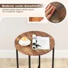 A round side table with a coffee cup and a magazine on it, set against a light-colored wall. Náhled obrázku produktu