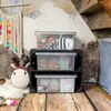 Storage boxes stacked on a wooden crate in a rustic setting. Anteprima dell’immagine prodotto