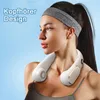 A woman wearing a headband and a sports bra, sporting a white neck fan against a light blue background. Produktbild-Vorschau
