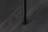 A close-up shot of a black metal chair leg resting on a dark wood floor. Produktbild-Vorschau