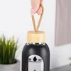 A hand holding a reusable water bottle by its loop. Voir les images du produit