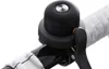 A close-up shot of a black bicycle bell mounted on a handlebar. Podgląd zdjęcia produktu