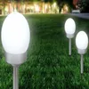Several solar garden lights are placed in a grassy yard with trees in the background. Produktbild-Vorschau