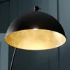 Close-up of a black dome-shaped lamp with a gold interior, showing the light source. Produktbild-Vorschau
