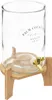 A clear glass beverage dispenser with a gold spigot sits on a wooden stand. Produktbild-Vorschau