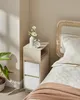 A narrow nightstand with two drawers and an open shelf next to a bed. Náhled obrázku produktu