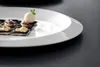 A close-up of small appetizers on a white plate. Produktbild-Vorschau