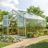 A greenhouse filled with plants, situated in a garden setting with a paved walkway. Produktbild-Vorschau