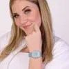 A woman wearing a blue digital watch. Náhled obrázku produktu