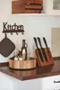 A kitchen counter with various items including a knife block, spice rack, and pot holder. Produktbild-Vorschau