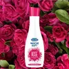 A bottle of laundry scent is placed in front of a backdrop of pink roses. Podgląd zdjęcia produktu