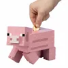 A hand is inserting a coin into a pink Minecraft pig piggy bank. Podgląd zdjęcia produktu