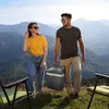 A couple carries a portable cooler in a scenic mountain landscape. Podgląd zdjęcia produktu