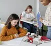 A teacher is showing a science experiment model to students in a classroom. Náhľad obrázku produktu