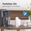 A coffee machine and a water filter are shown on a table, with decorative elements in the background. Náhled obrázku produktu
