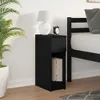 A black nightstand with a drawer and open shelf is placed next to a bed in a bedroom setting. A lamp and an alarm clock are on top of the nightstand, and books are in the shelf. A plant is to the left of the nightstand. Podgląd zdjęcia produktu
