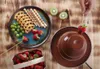 A chocolate fountain with various dipping items arranged on a wooden surface. Voir les images du produit