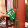 A hand is pulling a small green box with a white ribbon and the number 12 from an advent calendar. Náhled obrázku produktu