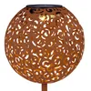 A close-up of a decorative solar-powered garden light shaped like a sphere with an intricate cut-out pattern. Produktbild-Vorschau