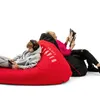 Two people relaxing on large beanbag chairs, one playing a video game and the other reading a magazine. Podgląd zdjęcia produktu