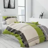 A bedroom setting with a bed dressed in green and beige plaid bedding. Náhľad obrázku produktu
