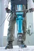 A person is using a demolition hammer in an indoor setting. Anteprima dell’immagine prodotto