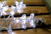 A close-up of a snowflake-shaped LED light decoration resting on wooden planks. Produktbild-Vorschau