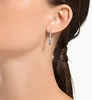 Close-up of a woman's ear wearing dangling earrings. Produktbild-Vorschau