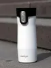 A white Contigo travel mug with a black lid sits on a gray, textured surface, possibly stairs. Anteprima dell’immagine prodotto