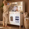 A young boy playing with a wooden toy kitchen. Produktbild-Vorschau
