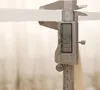 A digital caliper measuring the thickness of a white object. Voir les images du produit