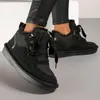 A person wearing black pants and black winter boots. Anteprima dell’immagine prodotto