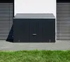 A dark gray metal storage box is placed on a paved patio in front of a white wall with horizontal blinds. Náhľad obrázku produktu