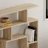 A close-up view of a modern, light wood bookshelf with books and a bowl on it. Podgląd zdjęcia produktu