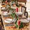 A beautifully set dining table for Christmas, adorned with festive decorations, greenery, candles, and tableware. Anteprima dell’immagine prodotto