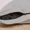 A close-up view of a light gray corduroy beanbag with a partially unzipped black interior. Voir les images du produit