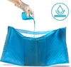 A hand wearing a glove pours liquid onto a blue pet hygiene pad. Podgląd zdjęcia produktu