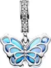 A close-up studio shot of a silver and blue butterfly charm with cubic zirconia stones on the bail. Podgląd zdjęcia produktu
