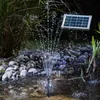 A solar-powered fountain operating in a garden pond at night, with water spraying upwards and illuminated by LEDs. Produktbild-Vorschau