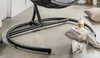 Close-up of the base of a hanging chair, showing its metal frame and the floor. Produktbild-Vorschau