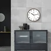 A modern living room with a wall clock and a cabinet. Voir les images du produit