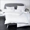 A neatly made bed with white bedding and a grey headboard. Produktbild-Vorschau