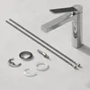 A chrome faucet and its installation parts are laid out on a light gray surface. Podgląd zdjęcia produktu